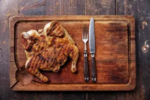 Knife Prints: Grilled fried roast Chicken tobacco on cutting board on dark wooden background