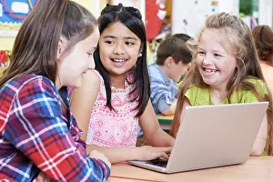 School Children Prints: Group Of Elementary School Children Working Together In Computer Class