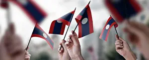 Activist Prints: A group of people holding small flags of the Laos in their hands A group of people holding small flags of the Laos