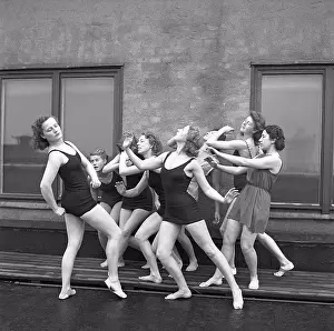 Team Work Prints: Gymnasts in the 1940s. A group of women gymnasts are training together on a top of a building