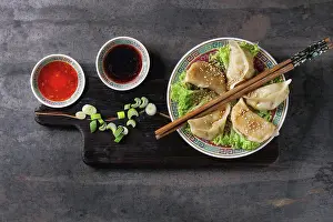 Back Ground Prints: Gyozas potstickers on lettuce salad with sauces