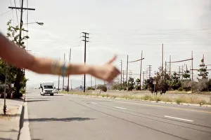 Orientation Prints: Hand of female hailing a ride during sunny day