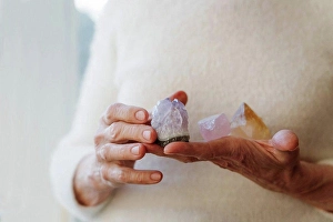 Spiritualism Prints: Hands of senior woman holding crystal stones