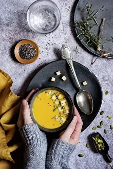 Flavour Prints: Hands of woman holding a hot pumpkin soup