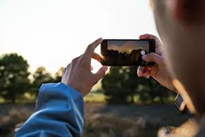 21 25 Years Old Prints: Hands of a young boy taking a photo with a smartphone