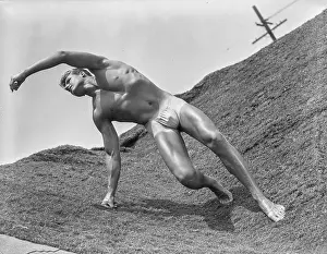 Bodybuilder Prints: Handsome Bodybuilder Stretches on Carpeted Stage c.1950