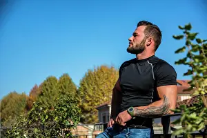 Macho Prints: Handsome dark haired young man looking out on the view Handsome dark haired young man standing in a balcony