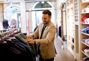 Apparel Prints: Handsome young man buying clothes in the store