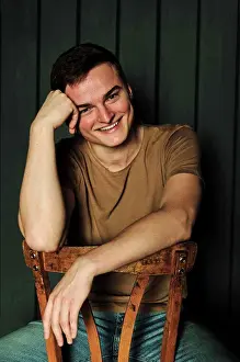 Thoughtful Prints: handsome young man in t-shirt and jeans laughs alone