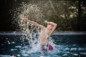 Swimming Suit Prints: happy 8 years old boy having fun in a swimming pool during summer