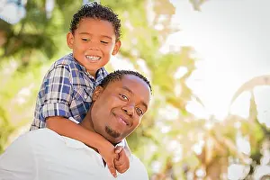 Sons Prints: Happy african american father and mixed-race son playing piggyback in the park