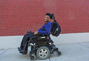 Cerebral Palsy Prints: Happy African American man with Cerebral Palsy using his power wheelchair outside