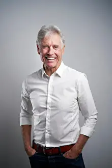 Pocket Prints: Happy businessman with hands in pockets in front of gray background