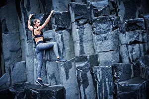 Determined Prints: Happy confident young women climbing on basalt rock in southern Iceland