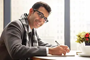 Blur Prints: A HAPPY CORPORATE PROFESSIONAL SITTING AND LOOKING AWAY WHILE WORKING IN OFFICE