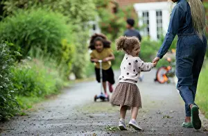 Home Prints: Happy daughter holding hands with mother on driveway