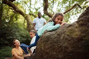 Multiethnic Prints: Happy family climbing tree in woods
