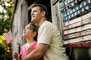30 To 35 Years Prints: Happy father and daughter standing in front of an American flag