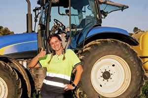 30 40 Prints: Happy female farmer gesturing thumbs up in front of tractor on sunny day