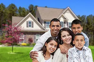 Looks Into The Camera Prints: Happy hispanic family portrait in front of beautiful house