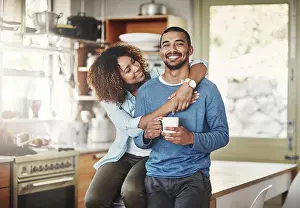 Getaway Prints: Happy, hugging and smiling young in love couple bonding in a kitchen at home
