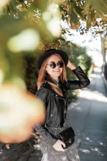 Niedlich Prints: Happy lächelndes Mädchen in Mode-Look mit Sonnenbrille und einen Hut mit einem stilvollen Handtasche ist im Herbst