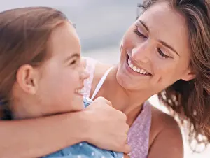Happy mother, child and hug with love at beach for support