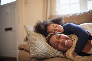 Sofa Prints: Happy mother and daughter cuddling on living room sofa