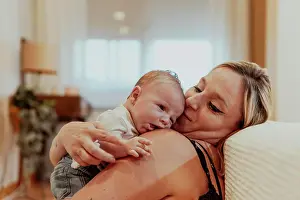 Parenting Prints: Happy mother looking at baby boy while sitting at home