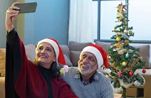 Husband Prints: A HAPPY OLD COUPLE CLICKING SELFIE AFTER DECORATING CHRISTMAS TREE
