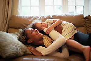 Sofa Prints: Happy playful mother and daughter on living room sofa