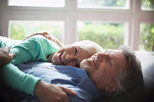 Cuddle Prints: Happy senior couple cuddling by sunny window