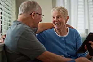 Baby Boomer Prints: Happy senior couple looking at an old framed photograph