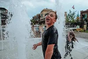 Gradeschooler Prints: Happy Teen Boy playing in fountains on summer day