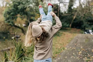 Hinreissend Prints: Happy young mother and little daughter fooling around outside in autumn