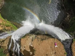 Breathtaking Prints: HAWAII - October 15 2016 : Aerial view of a man lying on the top of Wailua falls in Hawaii