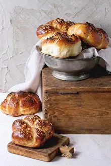 Seed Prints: Heap of sweet round sabbath challah bread with white and black sesame seeds in vintage metal bowl on wooden chest