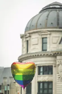 Colourful Prints: A heart shaped rainbow balloon floats in front of a building