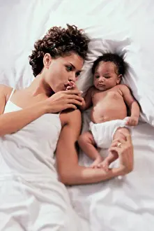 Beginnings Prints: High angle view of a mother lying on a bed with her baby boy