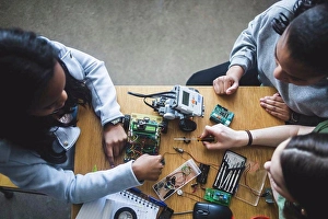 Problem Solving Prints: High angle view of multi-ethnic female students preparing science project at desk in high school classroom