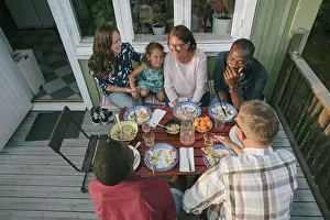 Midadult Men Prints: High angle view of multi-generation family having lunch at table on porch