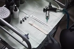 Work Tool Prints: High angle view of tattoo artist sitting by tools on table