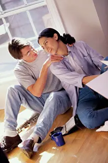 Looking Back Prints: High angle view of a young couple sitting on the floor