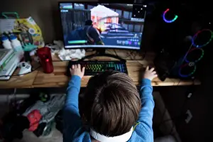 Electronics Prints: High View of Teen Boy Playing on Gaming Computer at Messy Desk