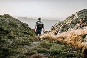 Agility Prints: hiker with white backpack descends through rocky trail