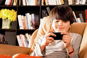 Joining Prints: Hispanic boy text messaging on cell phone