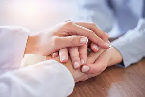 Doctors Prints: Holding hands, doctor and patient at desk for comfort