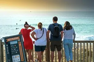 Evening Light Prints: Holidaymakers standing looking out over Fistral Beach in Newquay in Cornwall