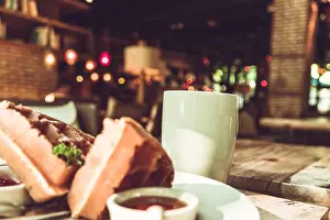 Lunch Prints: Hot mocha coffee in white cup and blurred waffle on the wooden table