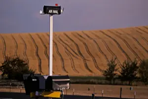 Days Prints: Humorous mailbox for airmail sits on tall pole above other mailboxes